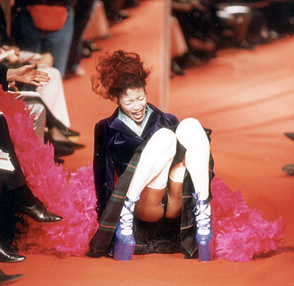 FASHION MODEL NAOMI CAMPBELL FALLS DURING THE VIVIENNE WESTWOOD FASHION SHOW IN PARIS, 1993. Poise, elegance and grace are the hallmarks of a top model. But they're wrtechedly difficult to maintain when you're totering along the catwalk in shoes with 5in platform soles and 12 in heels. Too difficult as it happened for Naomi Campbell, one of the star performers at Vivienne Westwood's stunning show during Paris Fashion Week. The 5ft 10in supermodel went form an elegant sashay to a crumpled heap in the blink of a false eyelash as she toppled over the purple, mock crocodile shoes. ...FASHION MODEL