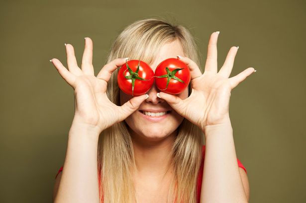 Young-woman-holding-tomatoes