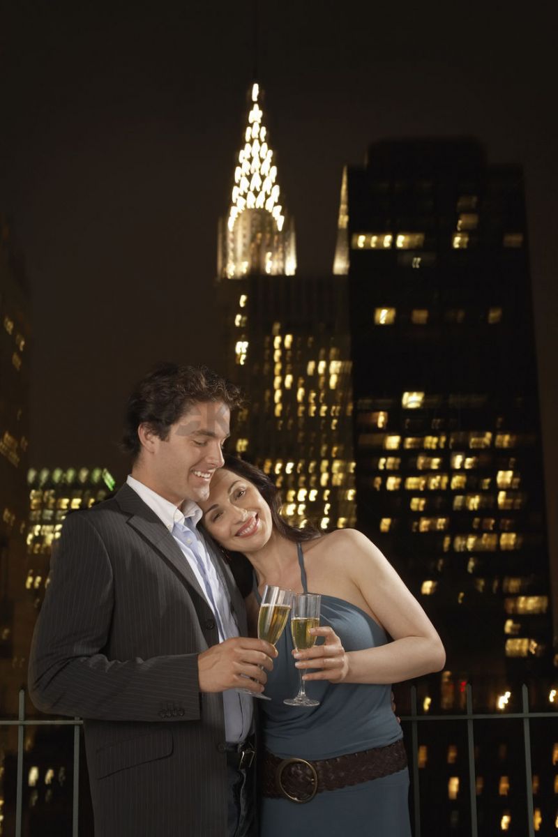 couple-toasting-with-champagne-against-new-york-night-skyline_1888935